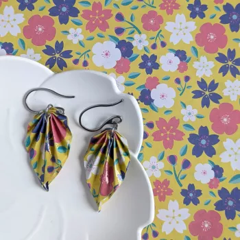 À côté des boucles d’oreilles, le papier origami utilisé pour façonner chaque feuille à la main.