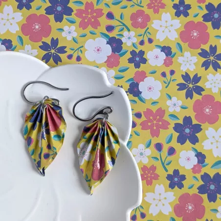À côté des boucles d’oreilles, le papier origami utilisé pour façonner chaque feuille à la main.