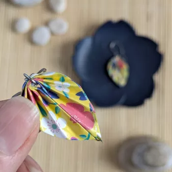 Gros plan sur les feuilles en origami sakura qui composent les boucles d’oreilles.