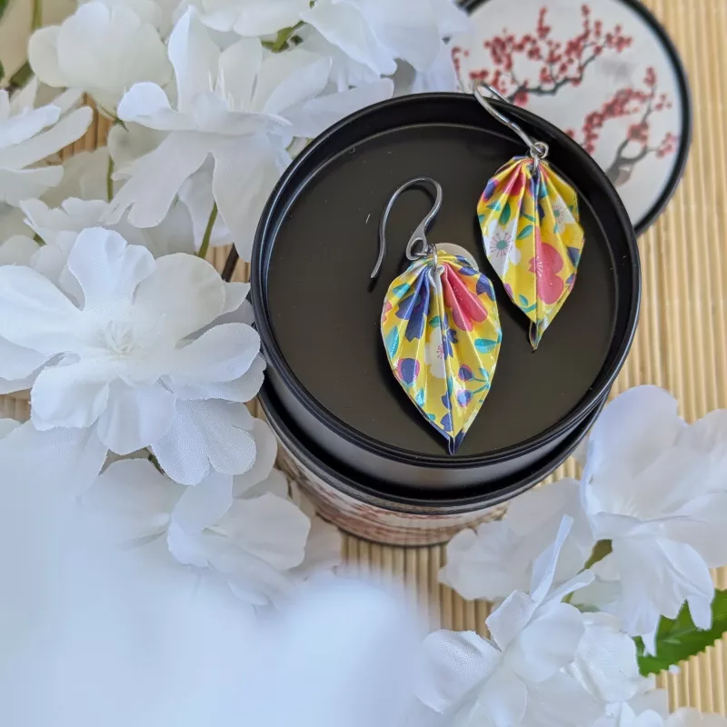 Boucles d’oreilles feuilles en origami sakura multicolores dans une mise en scène inspirée de l’univers japonais.
