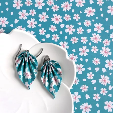 Les boucles d’oreilles accompagnées du papier origami turquoise à motifs sakura utilisé pour réaliser les feuilles.