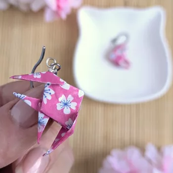 Boucles d’Oreilles Poissons Origami sakura blanches stylisées sur fond rose