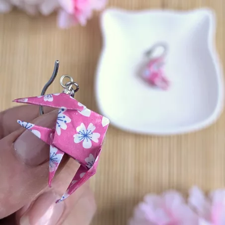 Boucles d’Oreilles Poissons Origami sakura blanches stylisées sur fond rose